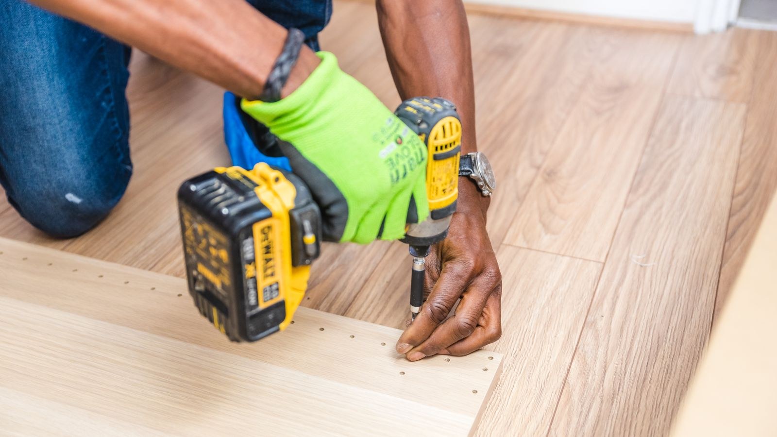 Handyman drilling into a wooden door during a keypad deadbolt install