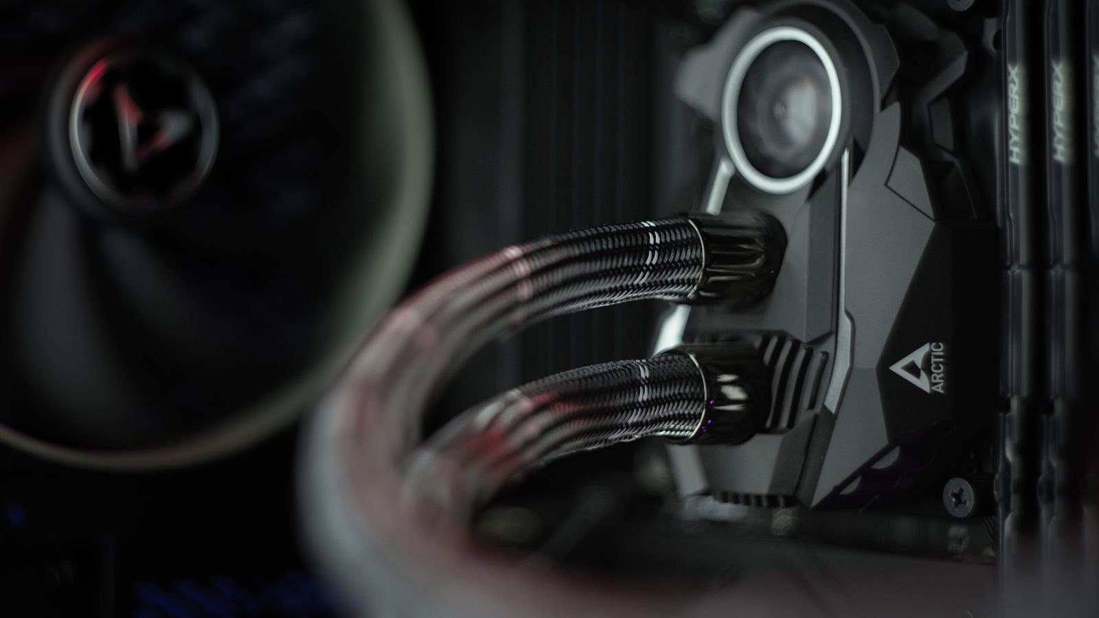 Hands installing a water block and fittings on a graphics card