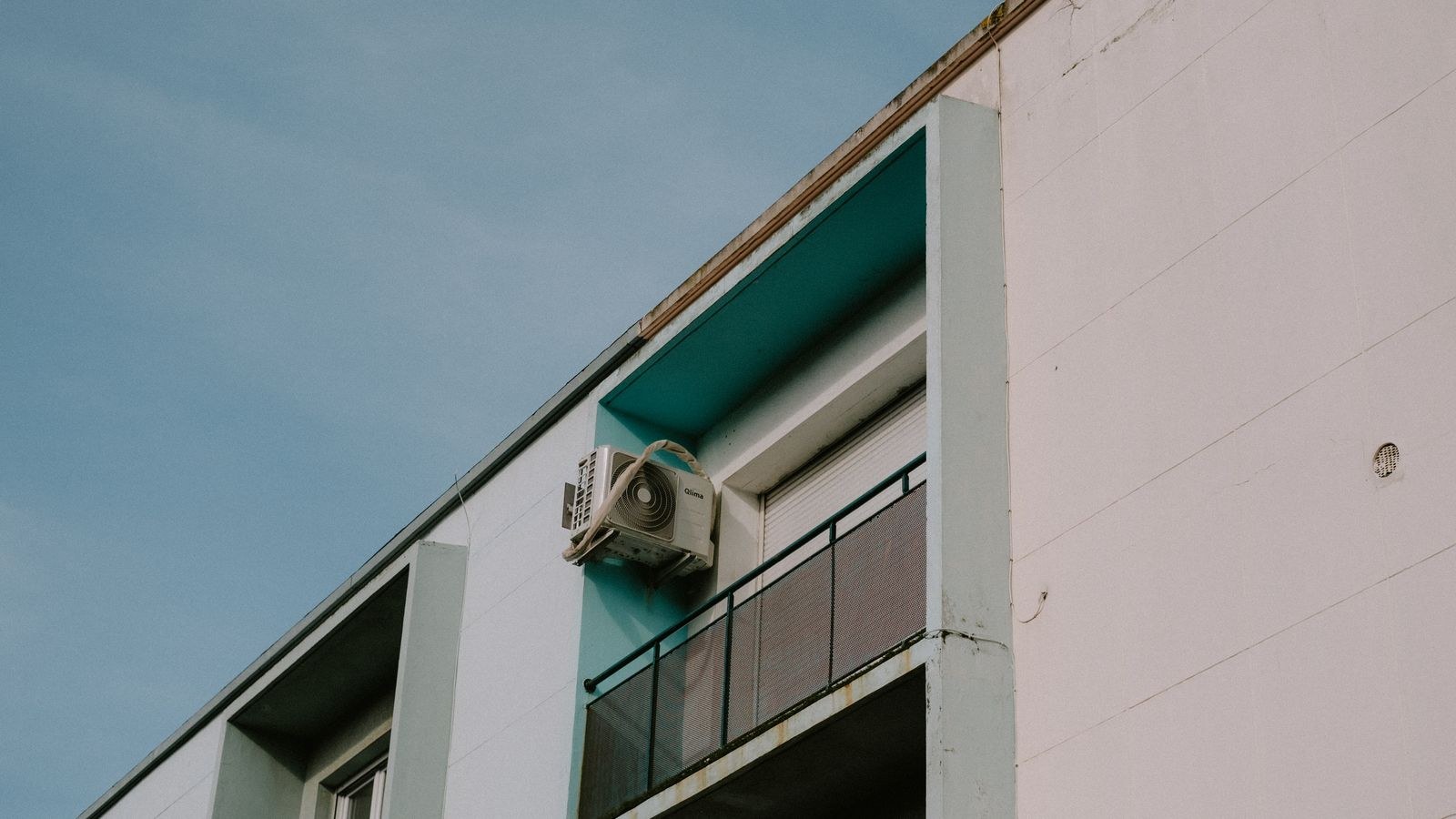Apartment balcony with an outdoor air conditioning unit mounted on the wall