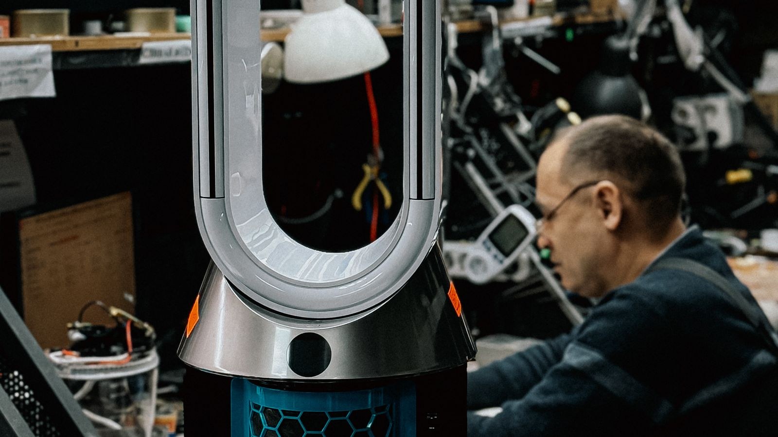 Air purifier with its filter housing open on a workbench during maintenance