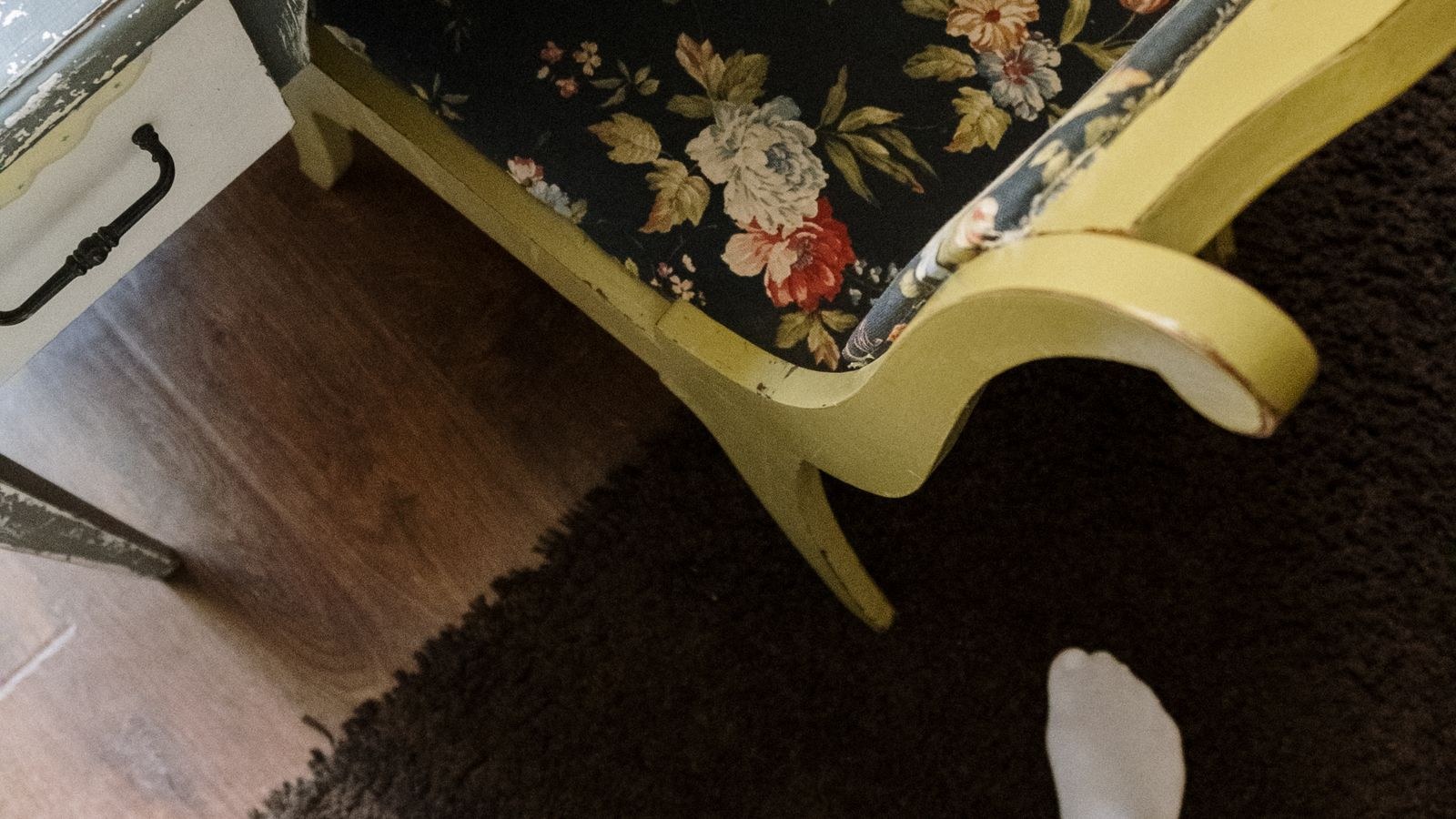 Home office desk and chair positioned on a floor rug in a bright room