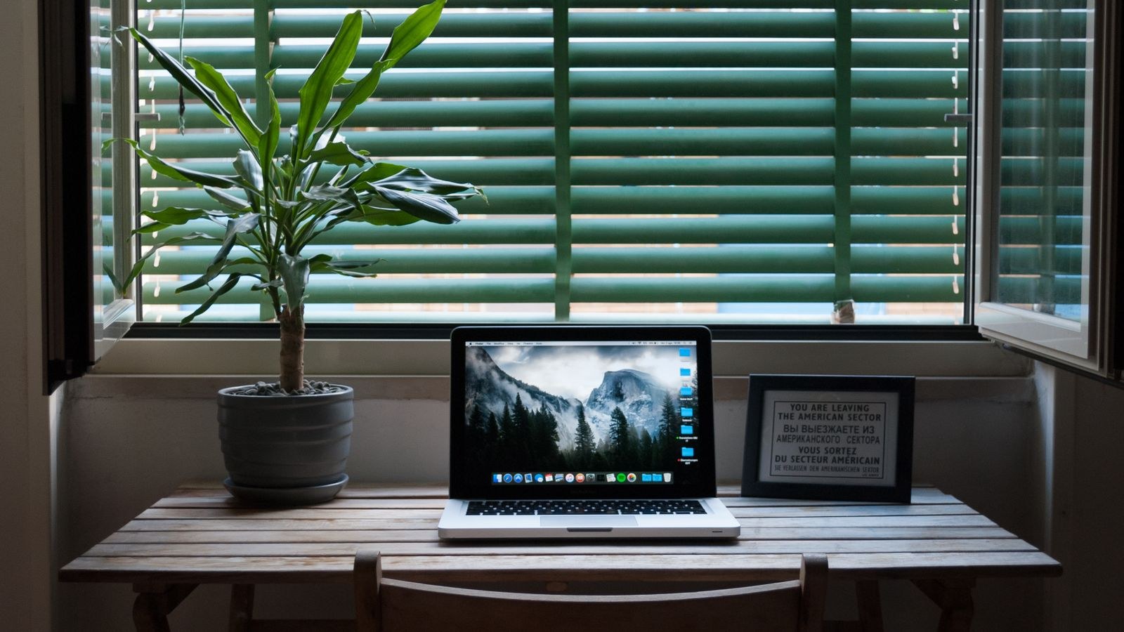 Elegant home office desk with a laptop positioned near natural window light