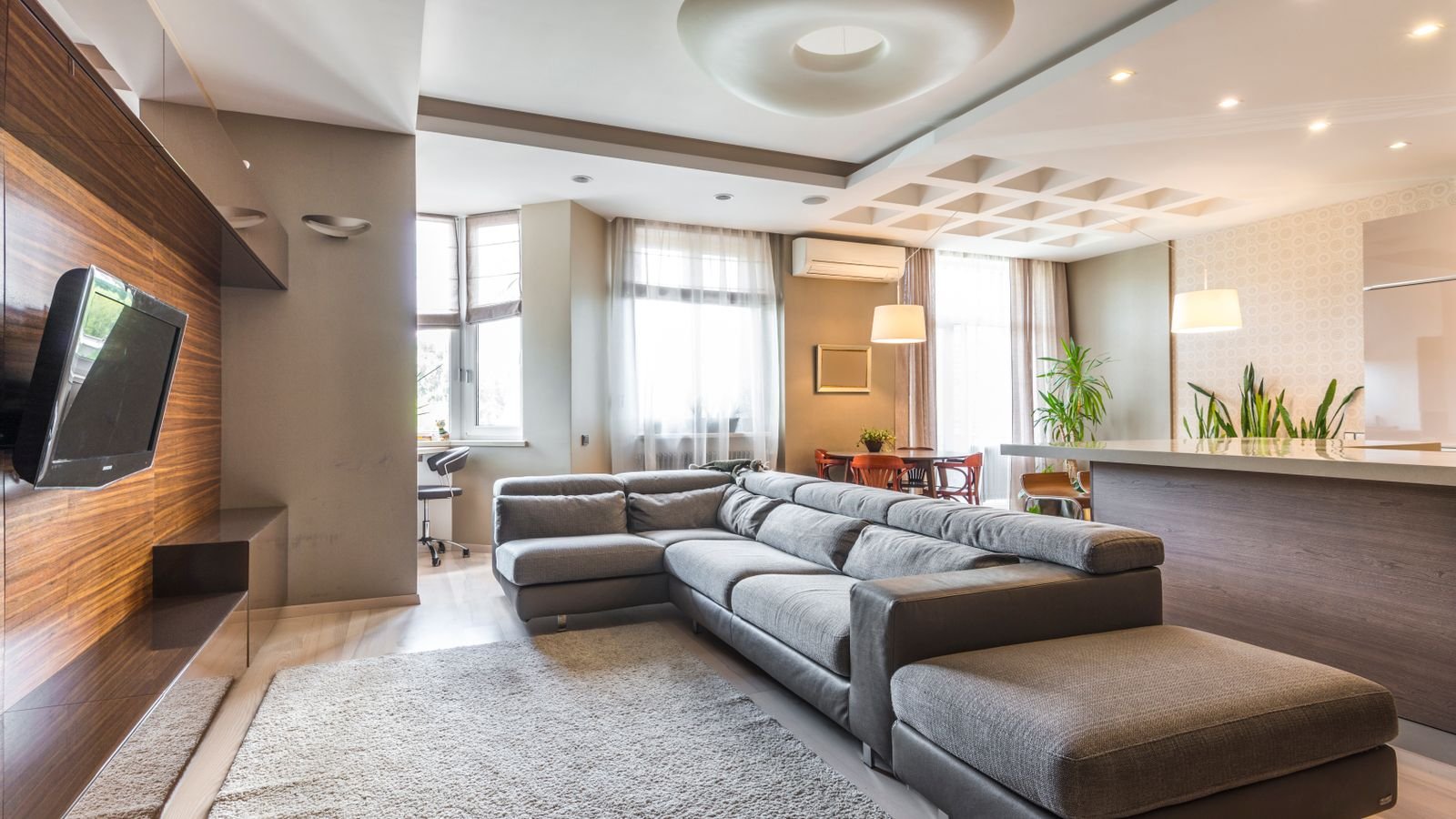 Modern basement living area lit evenly by ceiling recessed lights