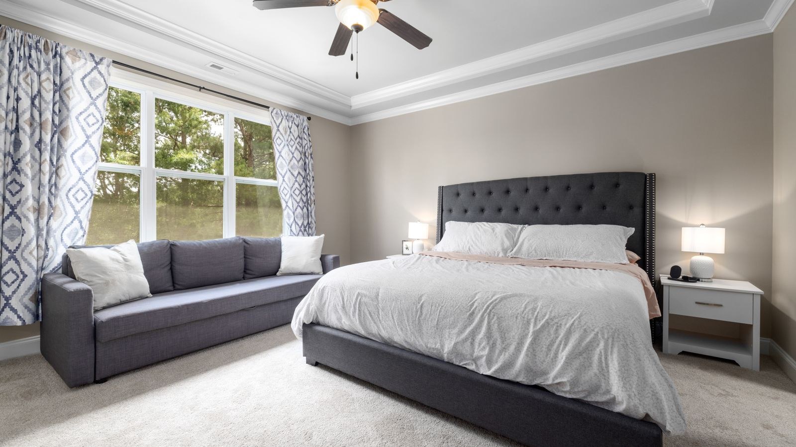 Minimalist bedroom with a king sized bed and natural light from a window