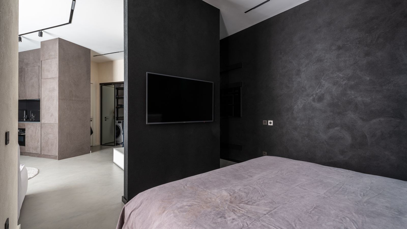 Contemporary bedroom interior with a large bed facing a modern television