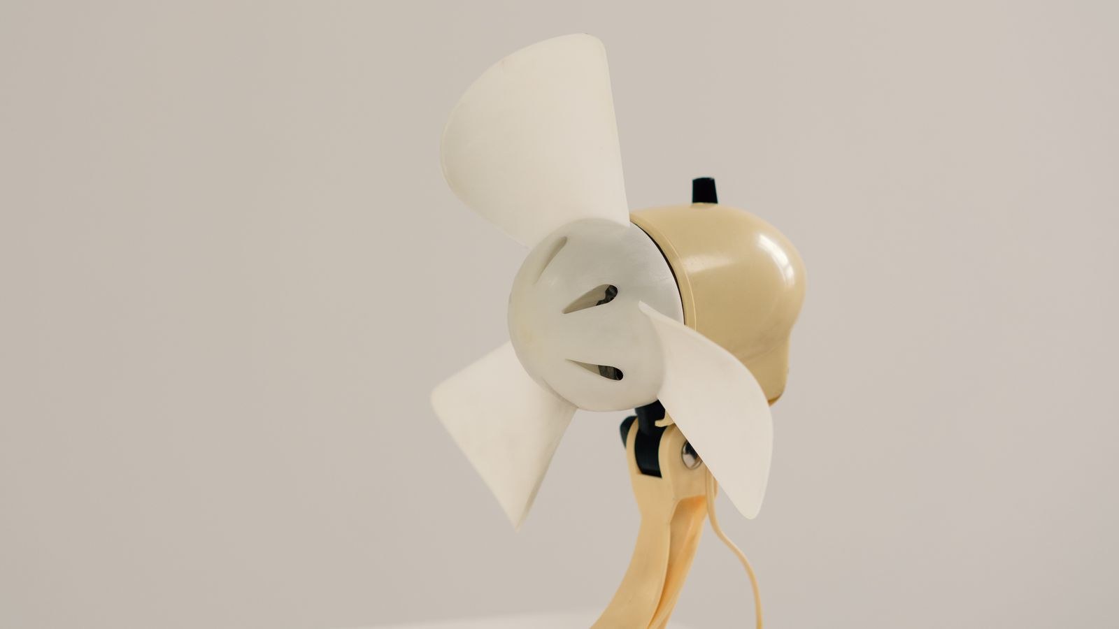 Sleek cream coloured desk fan on a minimalist white table