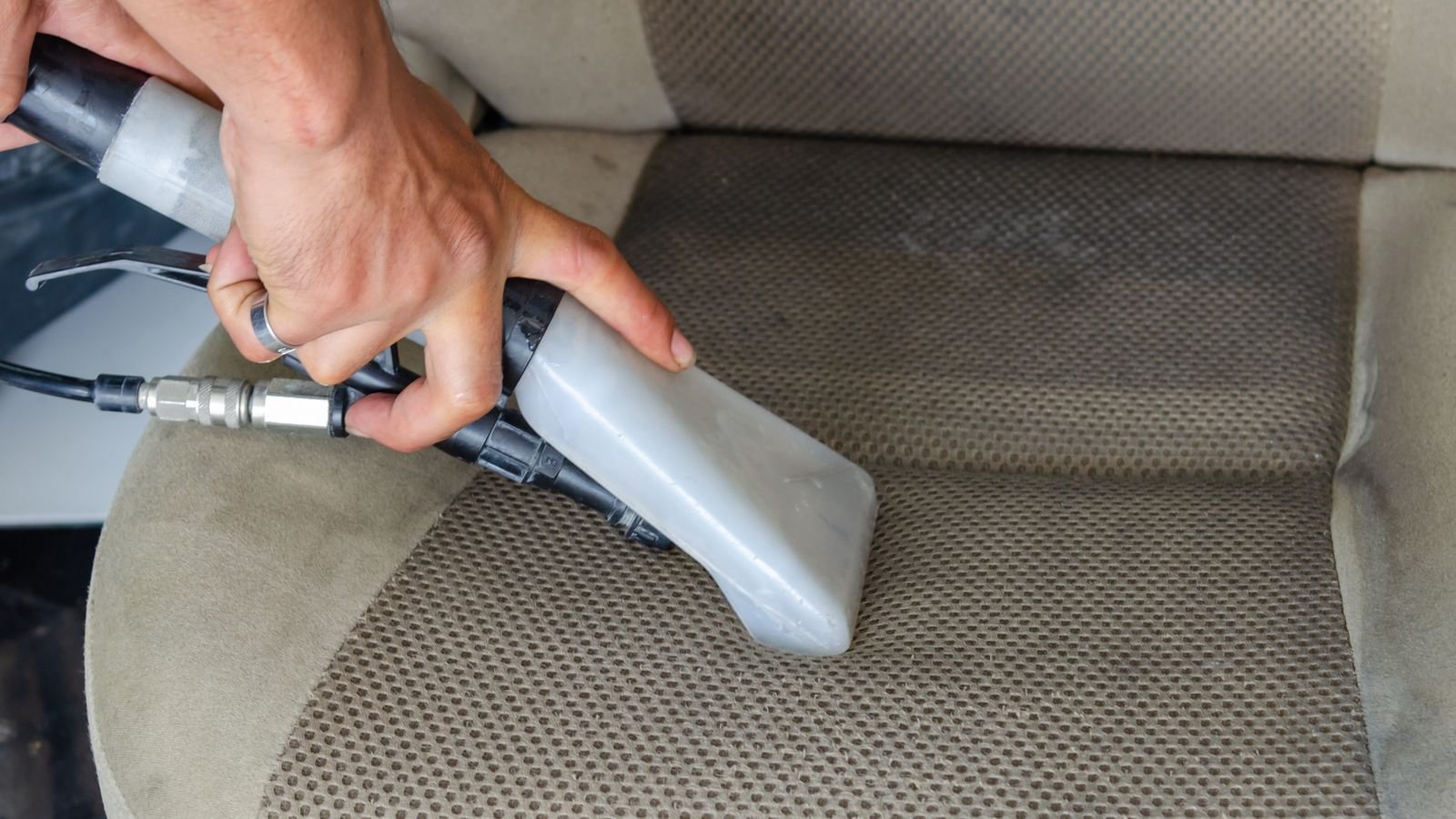 Vacuum nozzle deep cleaning a fabric car seat