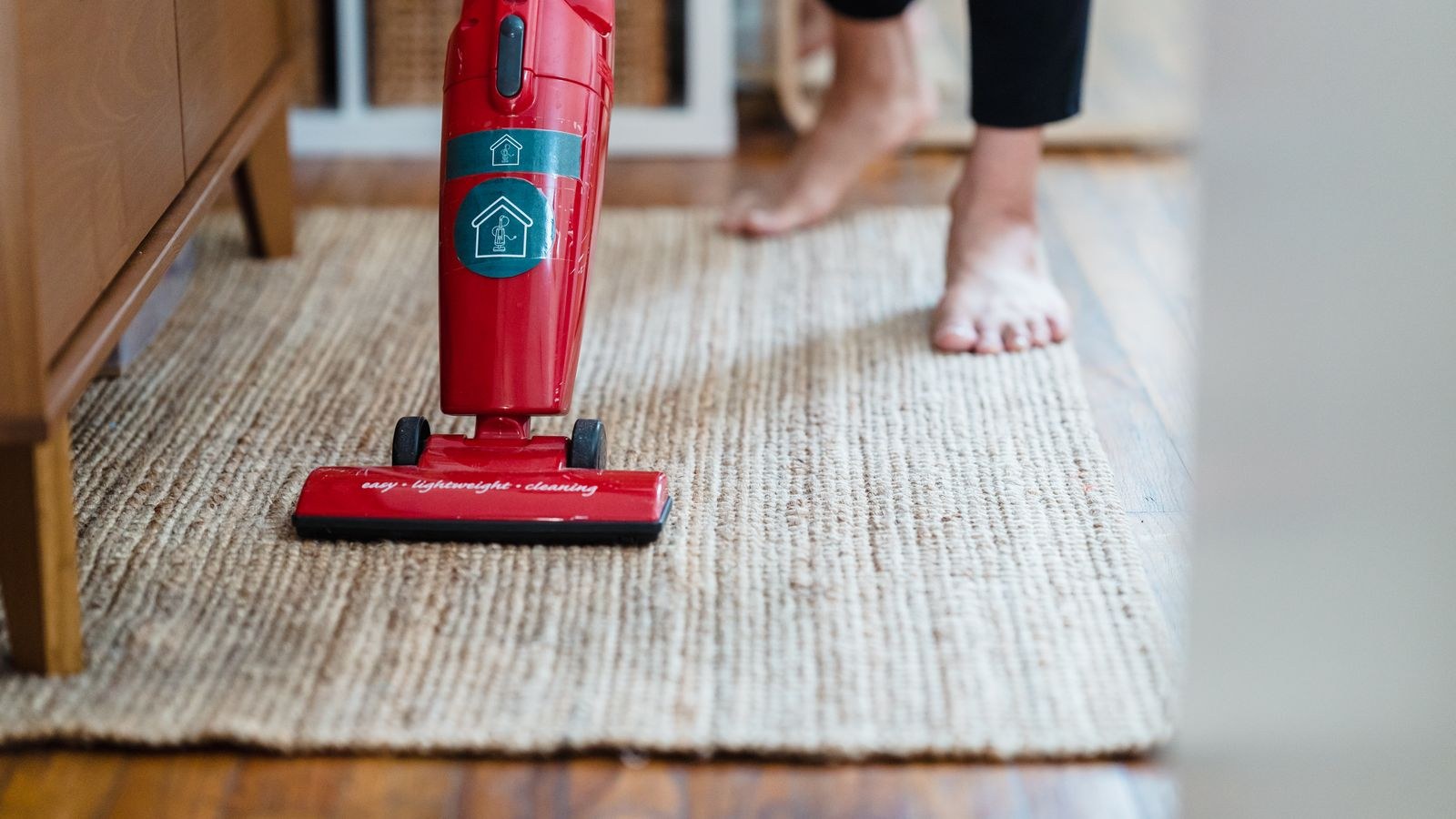 Compact carpet cleaning machine standing on a patterned carpet in a home