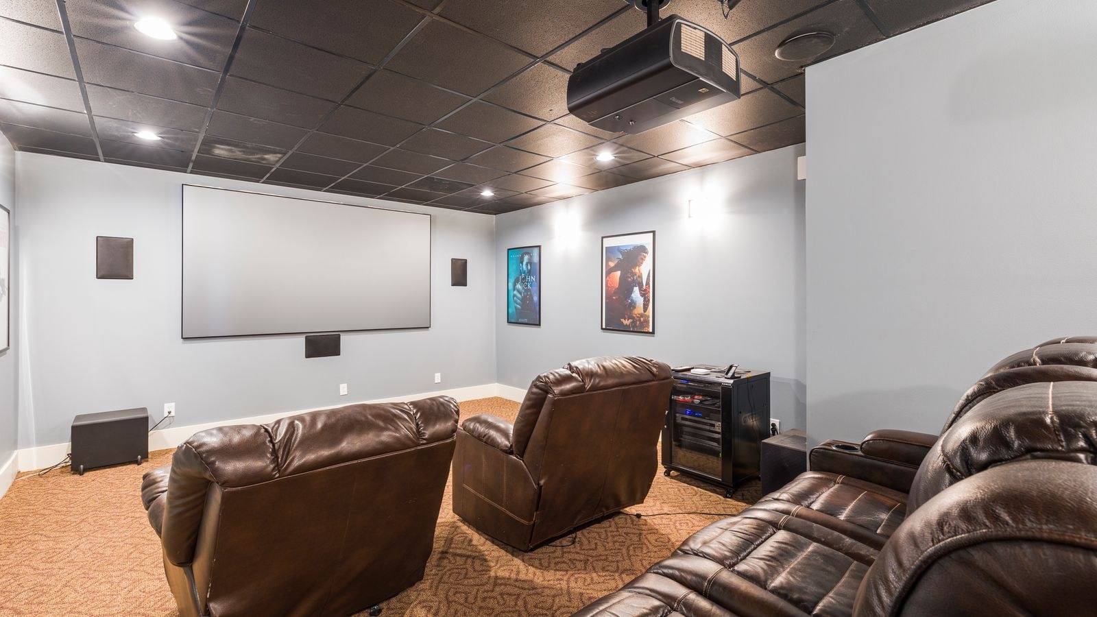 Home theater room with recliners and mounted audio visual equipment