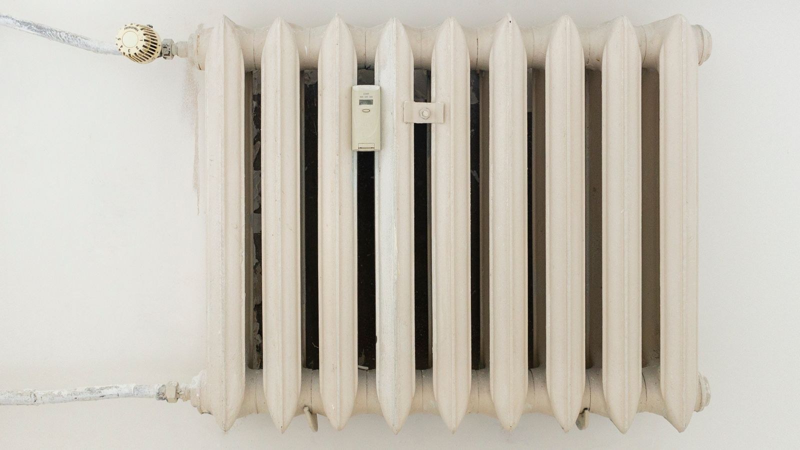 Classic white metal radiator heater in a minimalist room