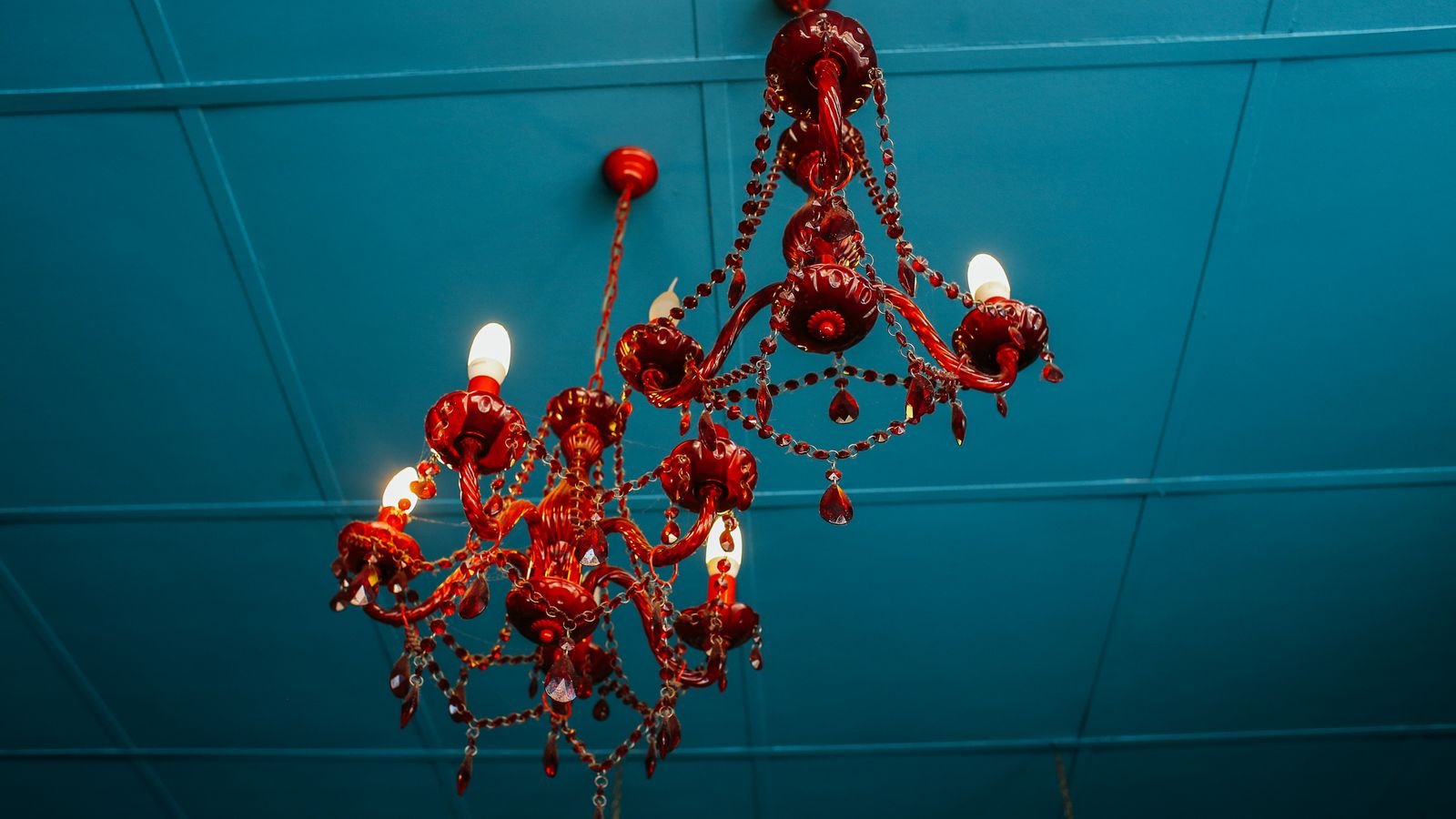 Vintage filament candelabra bulbs glowing in a decorative light fixture