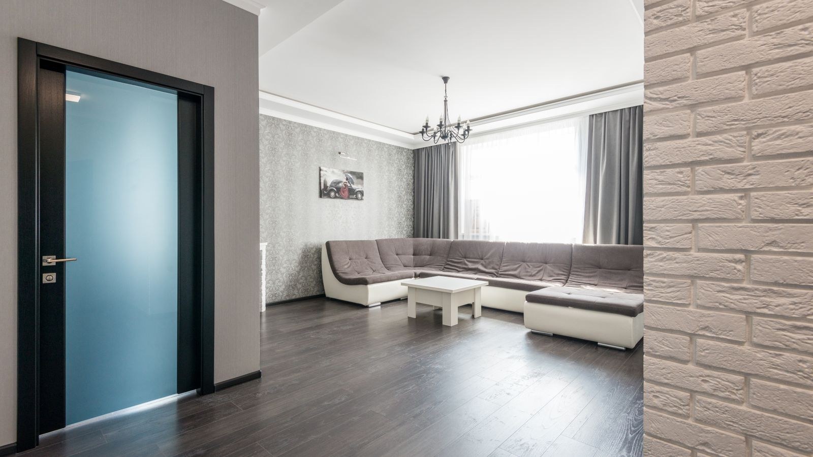 Spacious living room with wooden floor and comfortable beige sofa