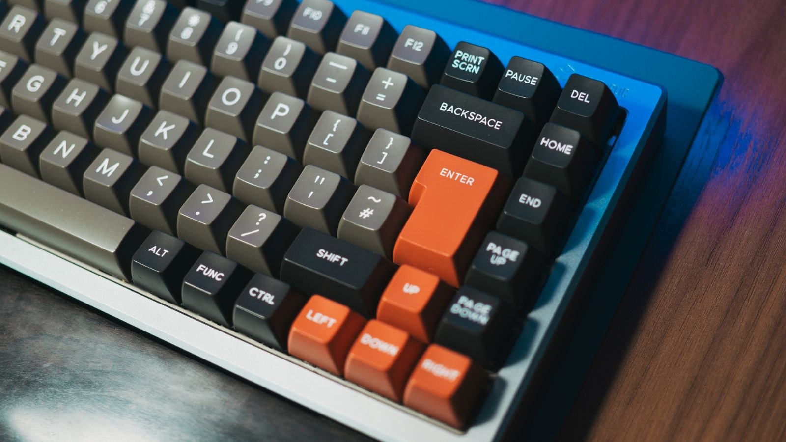 Close up of a mechanical keyboard with colored keycaps on a wooden desk