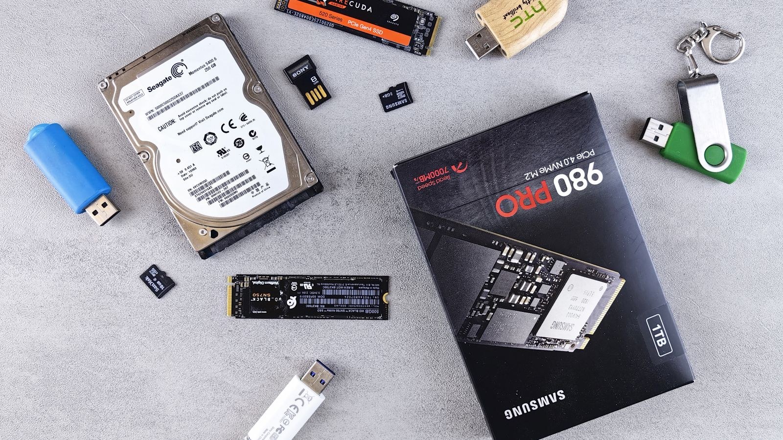 Assorted computer storage devices including SSDs and drives on a desk