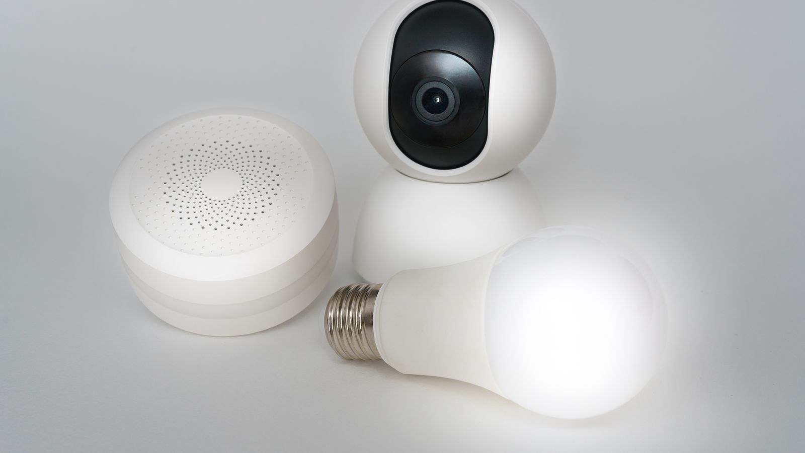 Set of smart home devices including camera speaker and lightbulb bridged into Apple Home