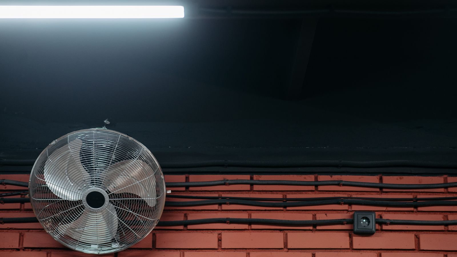 Electric floor fan circulating air near an open window