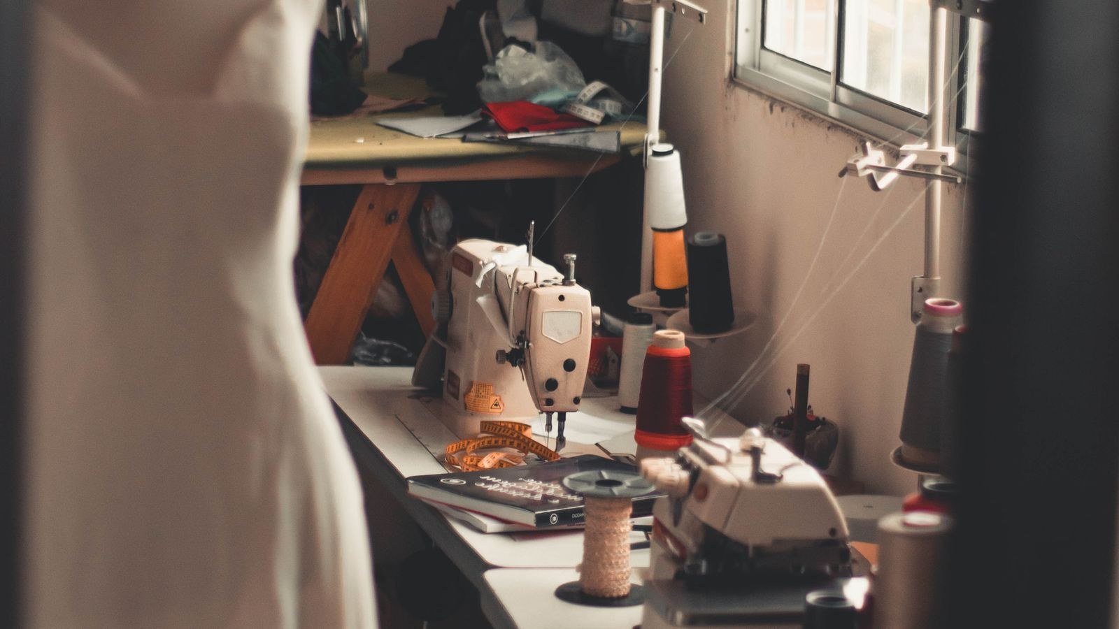 Warm home sewing room with dress form machines and craft lighting