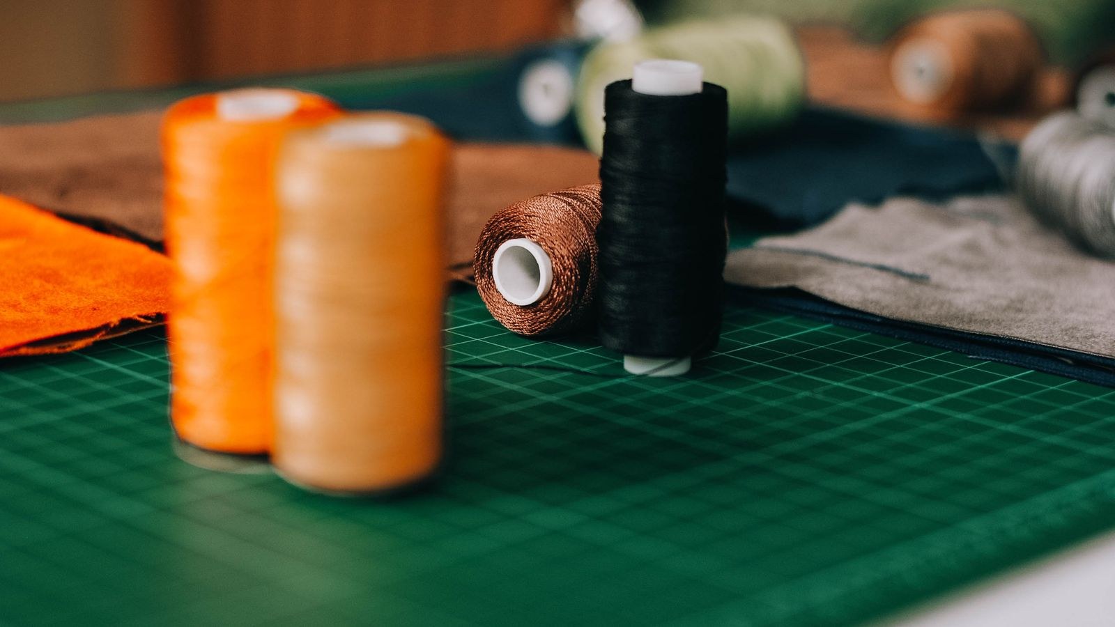 Colorful sewing threads on a cutting mat in a well lit craft room