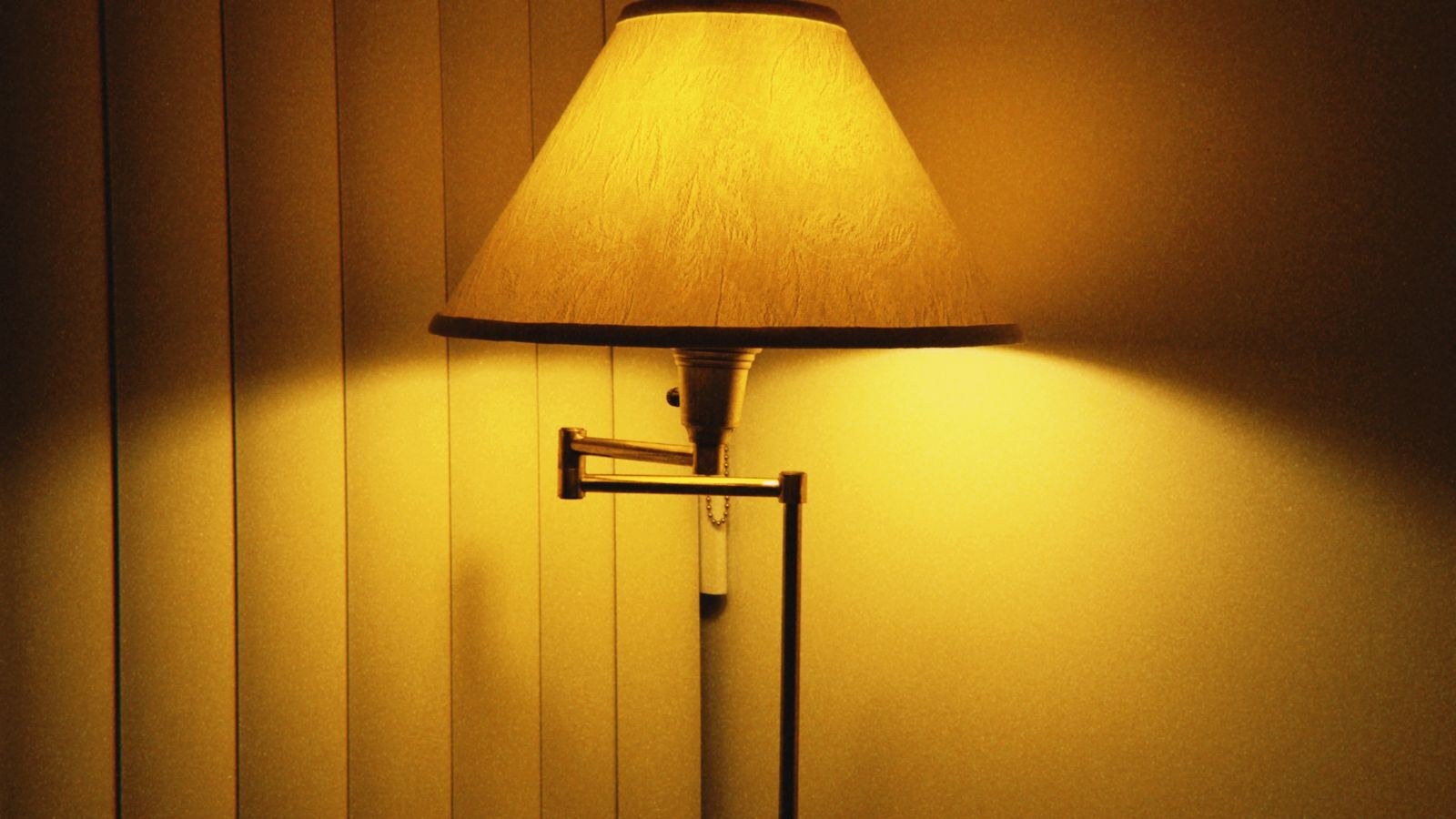 Floor lamp casting warm ambient light into the corner of a dim room