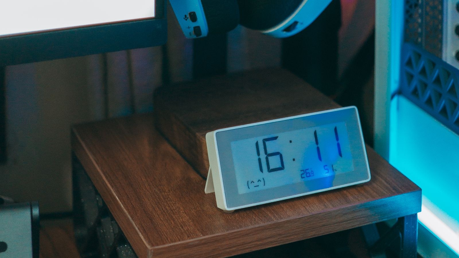 Close up of desk accessories including a digital clock and headphones