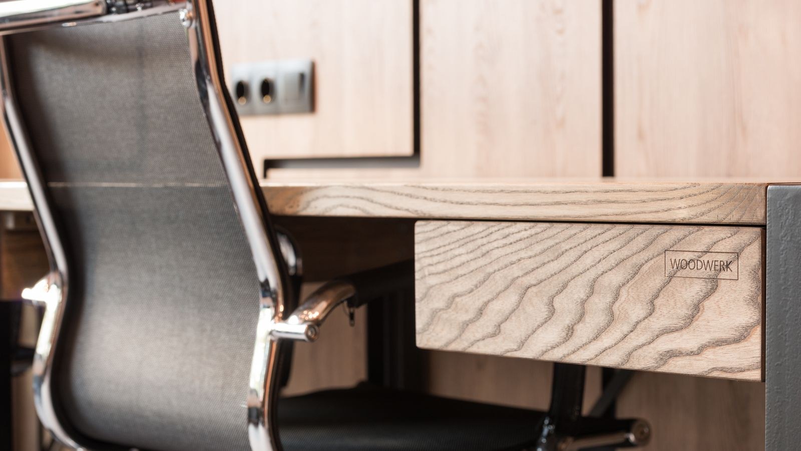Contemporary workspace with a curved wooden table and armchair