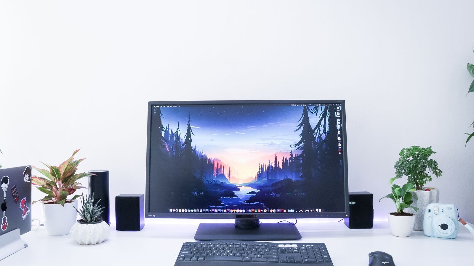 Contemporary minimalist desk featuring a monitor plants and electronic devices