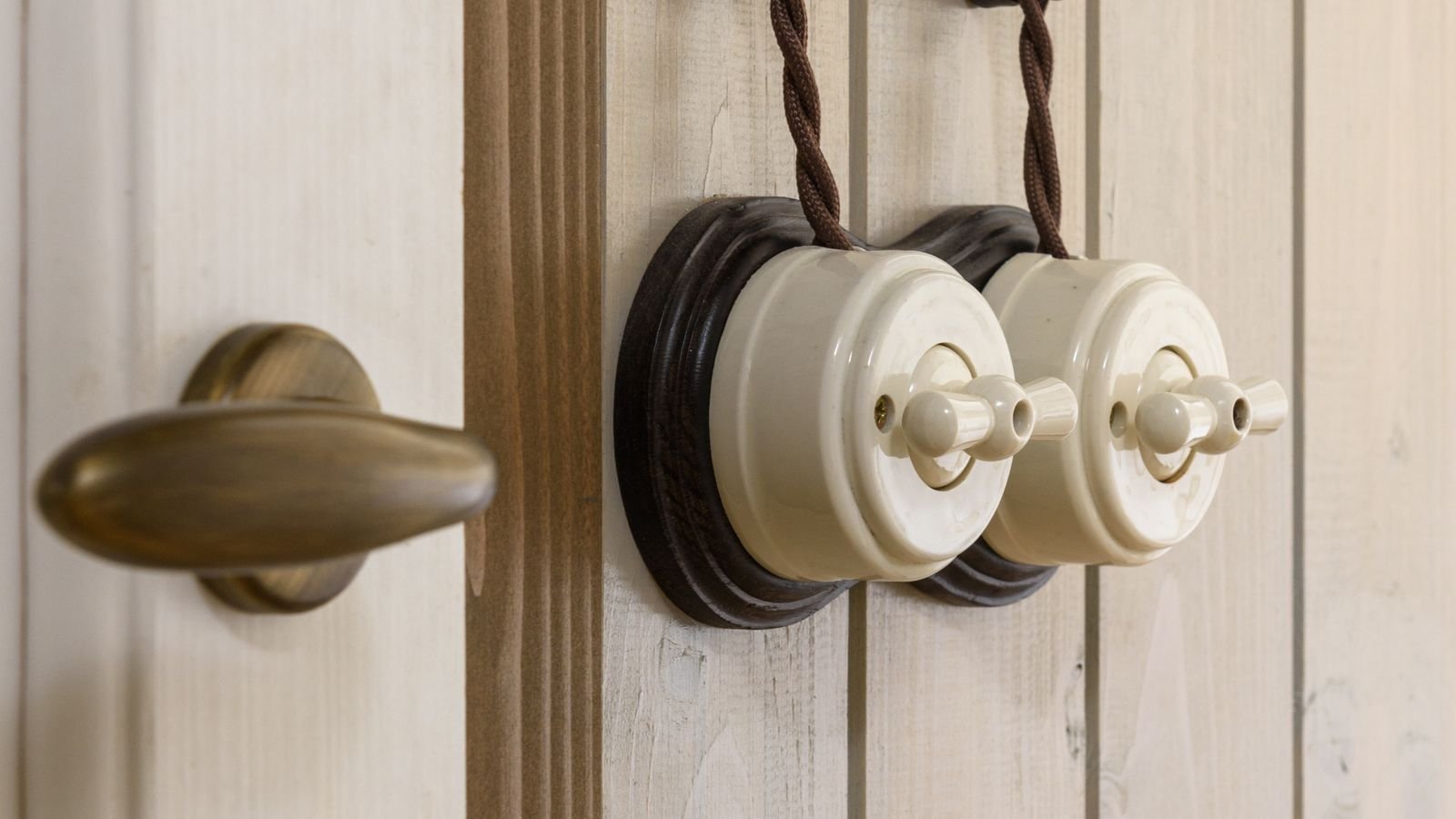 Hand adjusting a wall dimmer switch to control light brightness