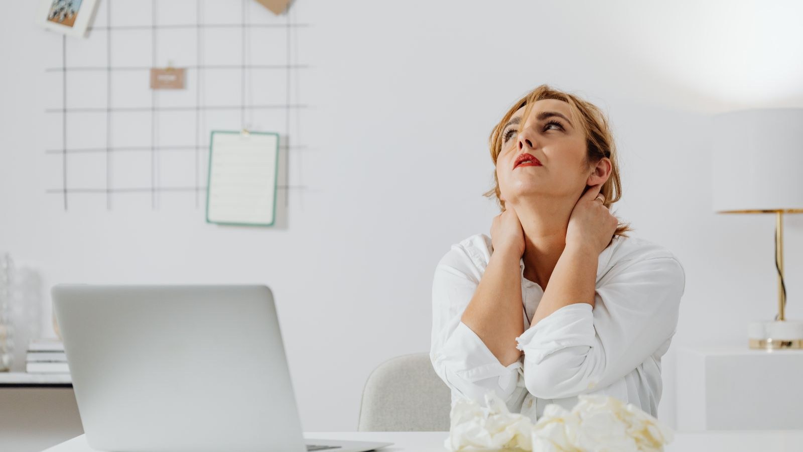Person reclining in an office chair with head supported during a break