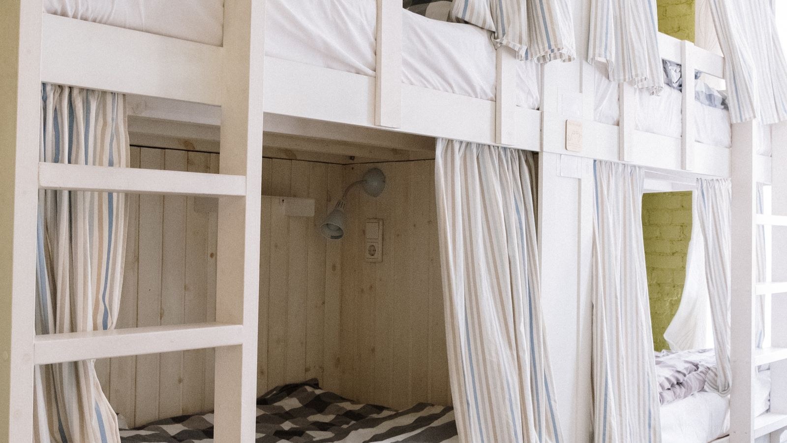 Dorm bunk beds with privacy curtains and personal storage space