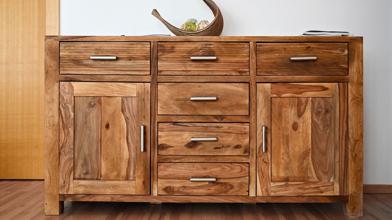 Tall wooden storage cabinet with sleek handles and natural wood grain finish