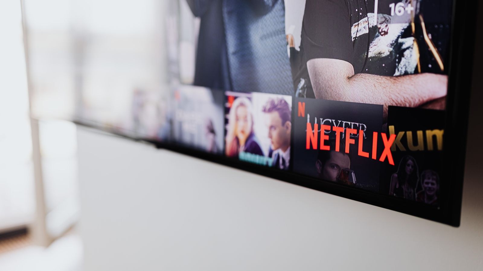 Flat screen television switched on and displaying content in a living room