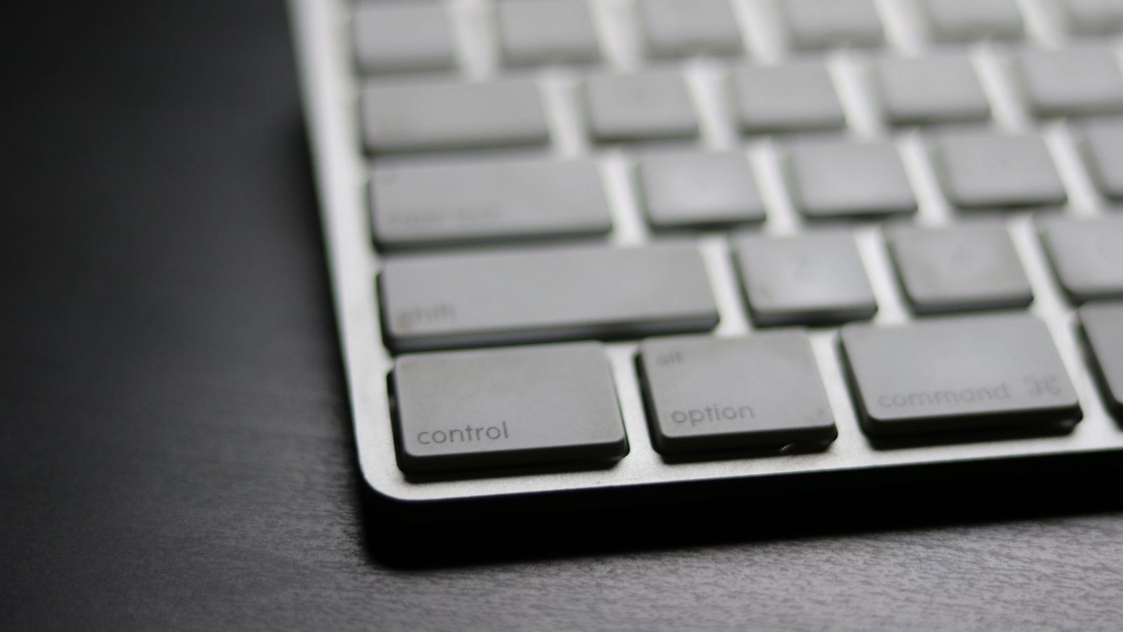 Close up of a sleek modern wireless keyboard on a dark surface