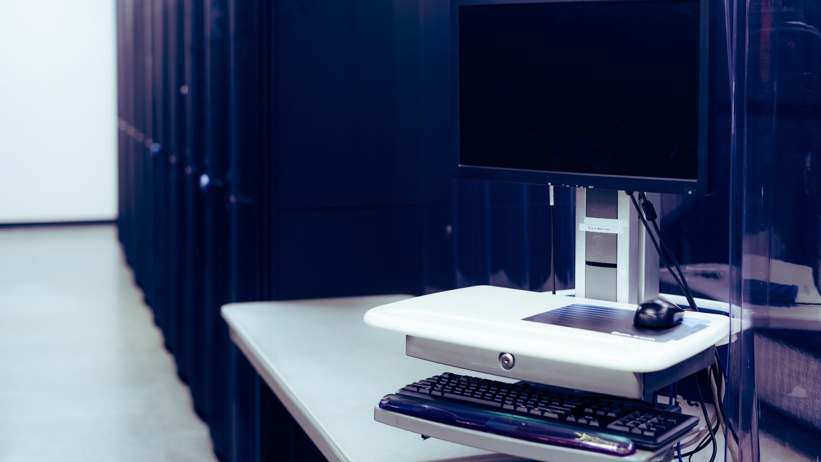 Desktop computer with dark screen next to hardware in an office