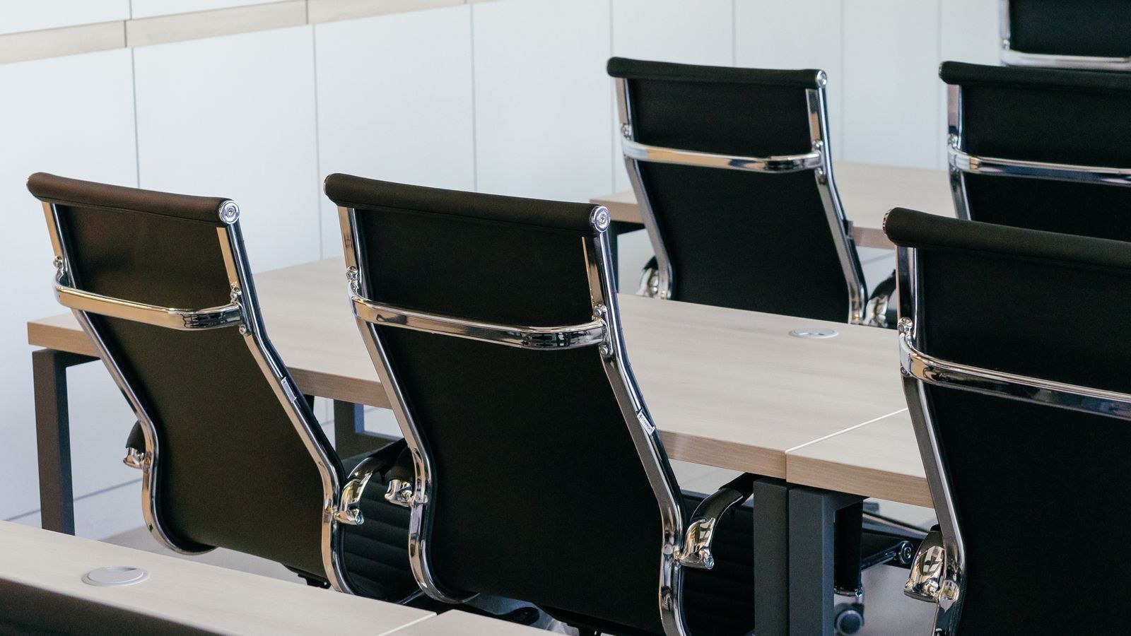 Empty conference room with black office chairs and wooden desks
