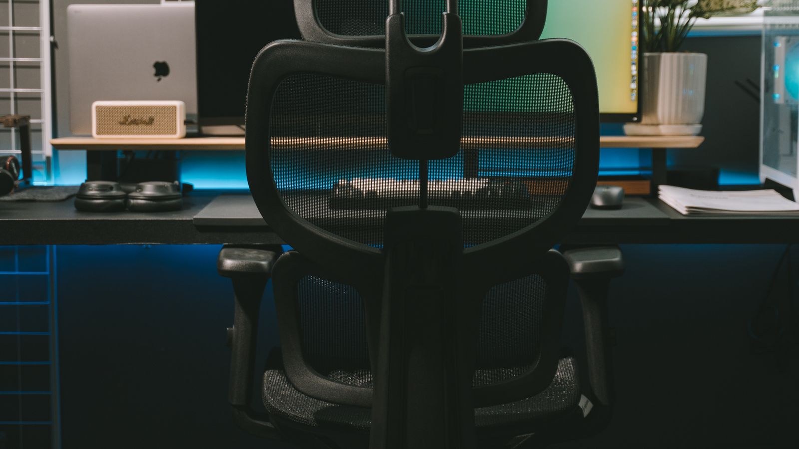 Modern ergonomic chair with adjustable backrest at a desk with a widescreen monitor