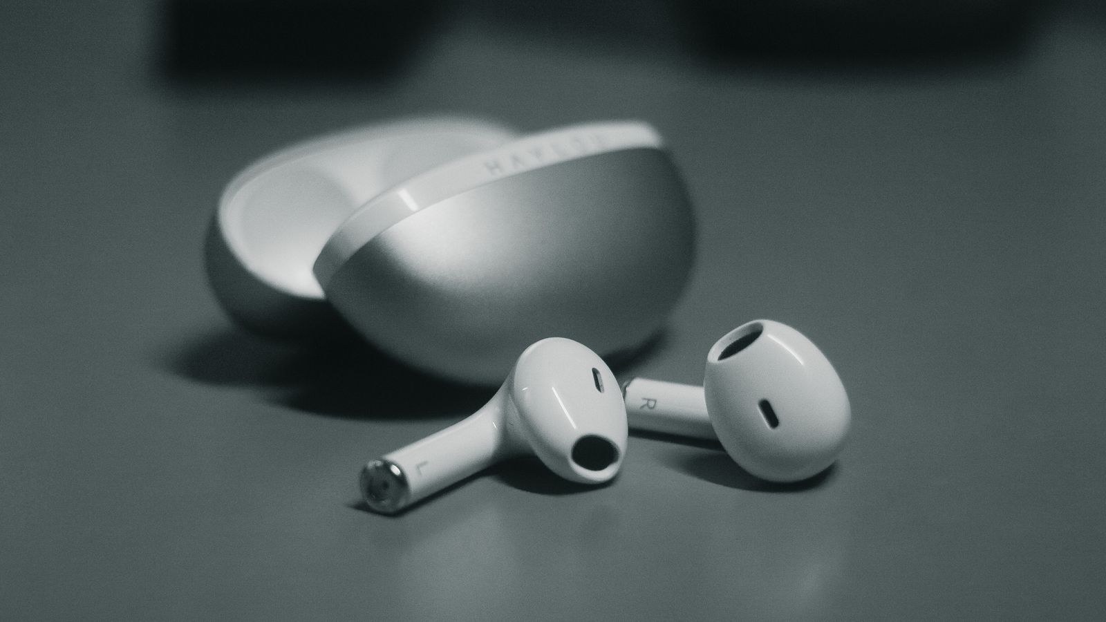 Wireless earbud sitting outside its charging case during troubleshooting