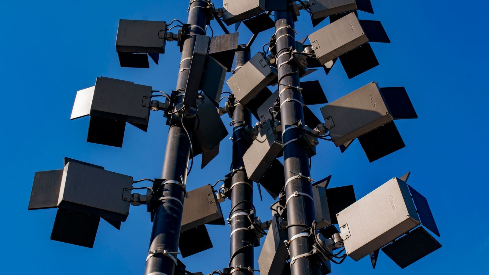 Outdoor floodlights mounted on a tall pole against the sky