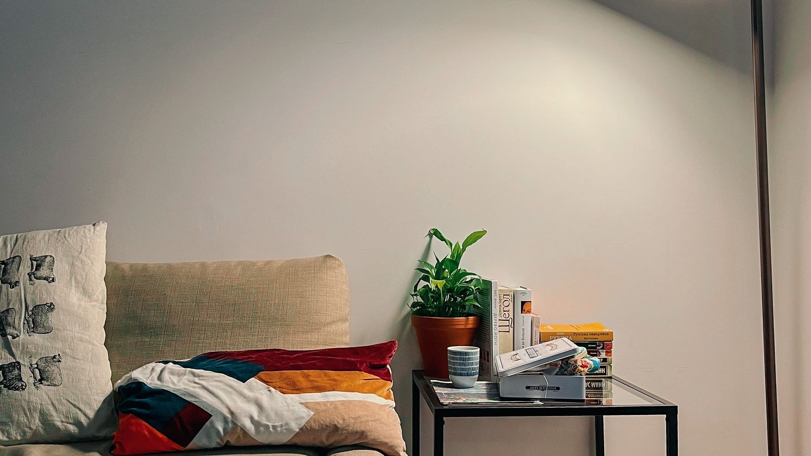Modern living room with a sofa and a slim floor lamp providing ambient light