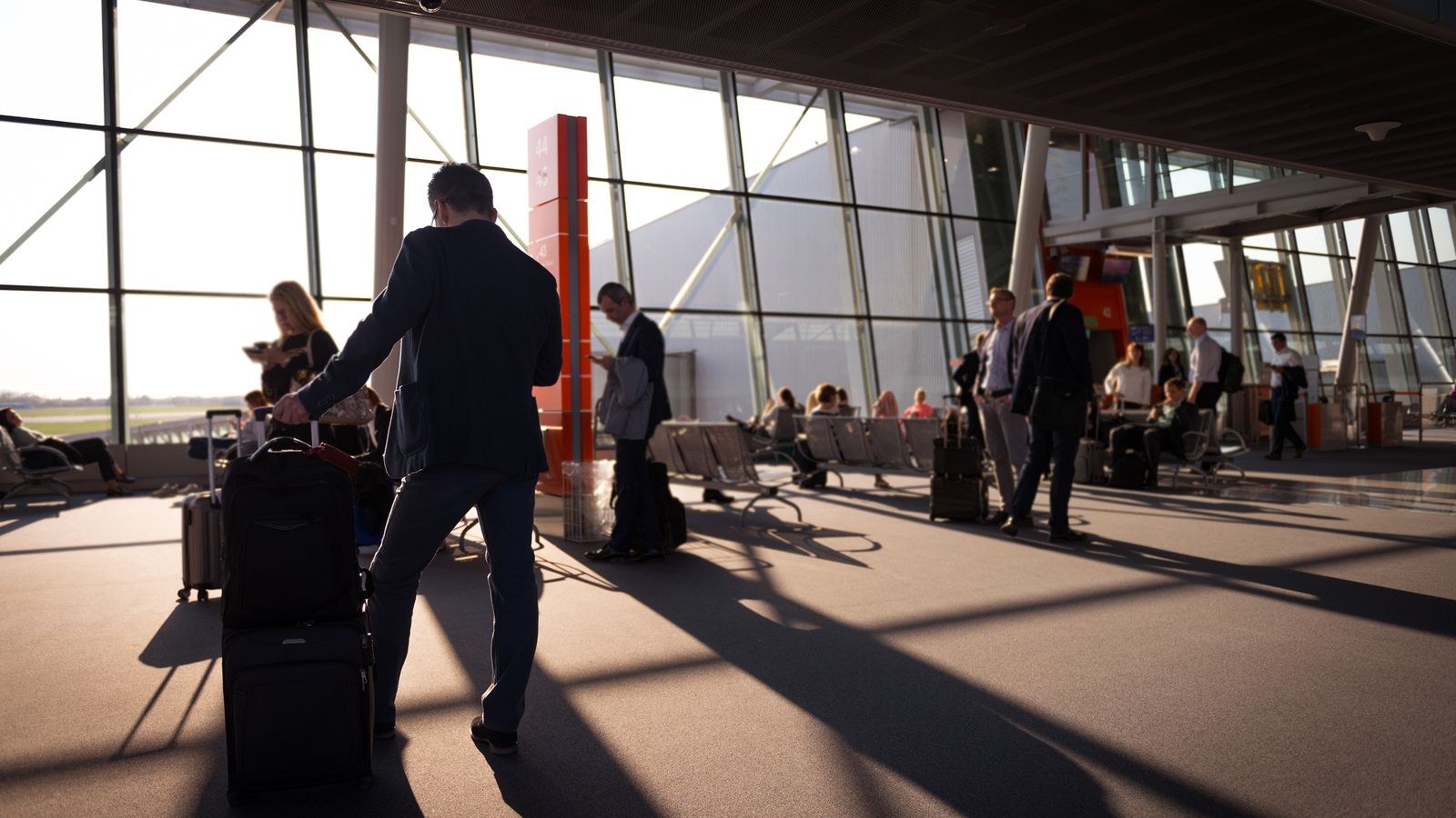 Traveler with carry-on luggage at an airport terminal