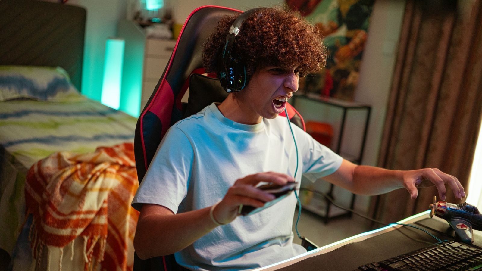 Teenager gaming at a desk in a modern home gaming chair setup