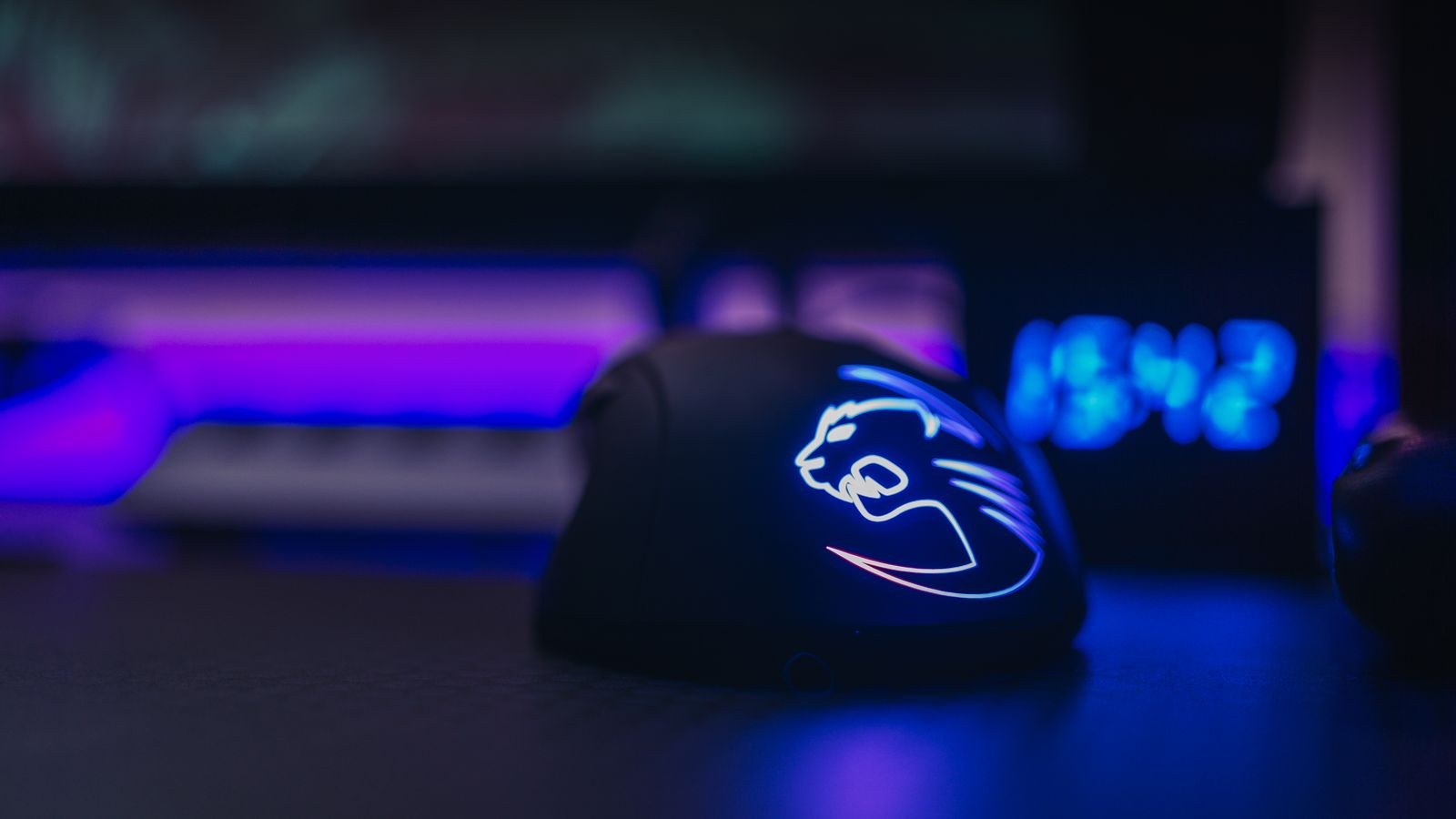 Illuminated gaming mouse with LED lighting on a dark desk