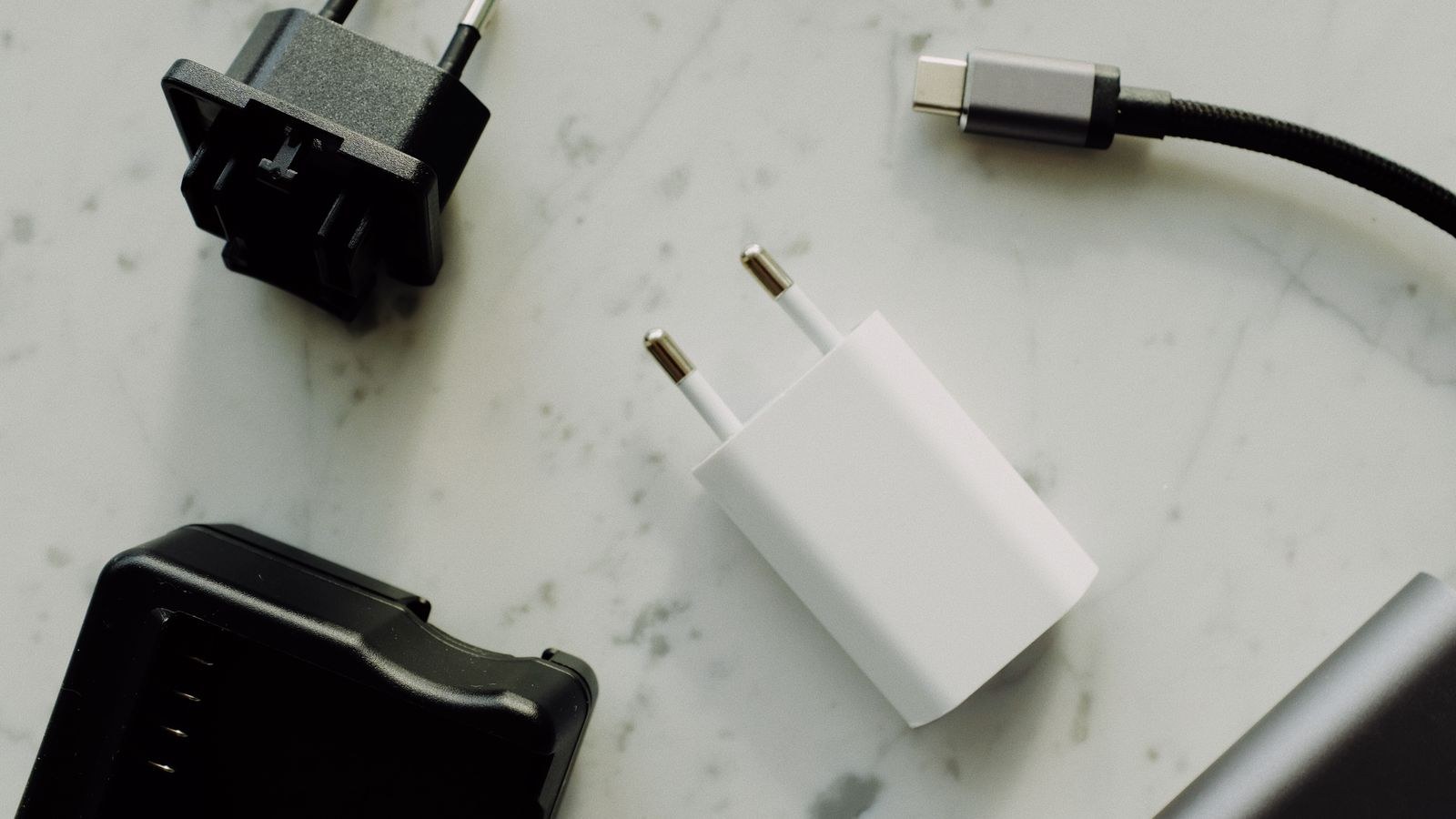 Several power adapters and a USB-C charging cable arranged on a surface