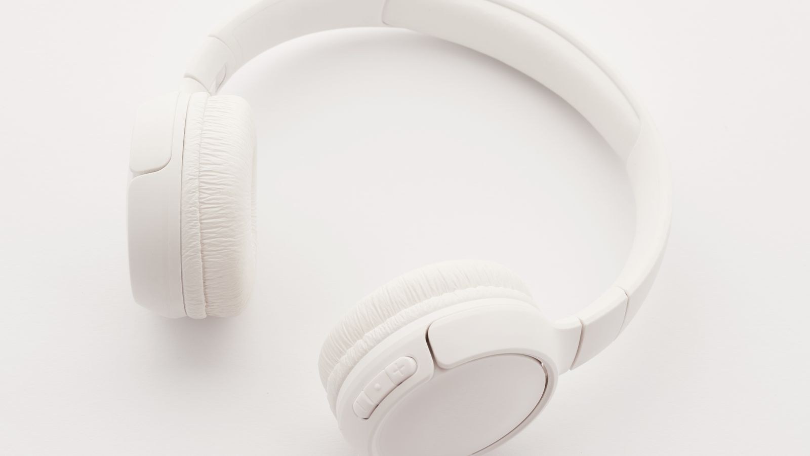 Modern white wireless headphones viewed from above on a clean background