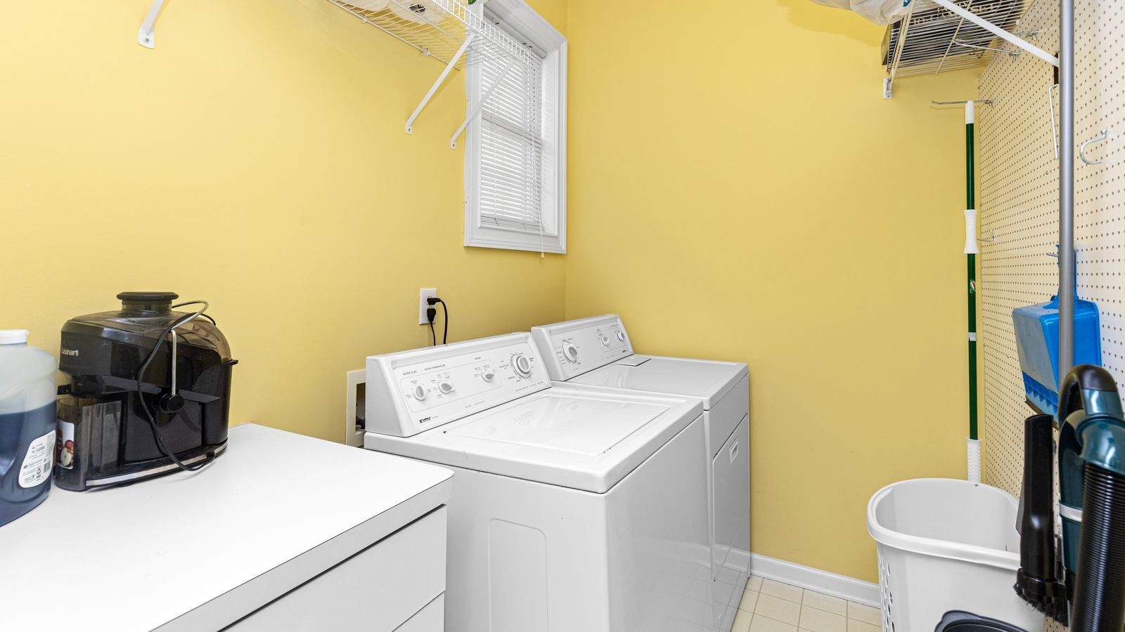 Compact heat pump dryer stacked above a washing machine in a home laundry closet