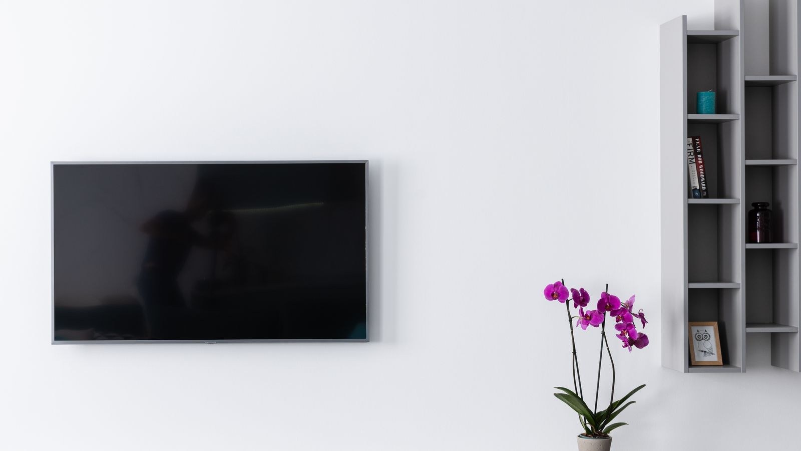 Recessed wall outlet and cable pass through behind a mounted television