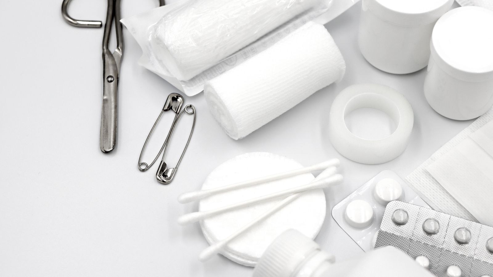 Flat lay of first aid supplies including bandages, scissors and gloves