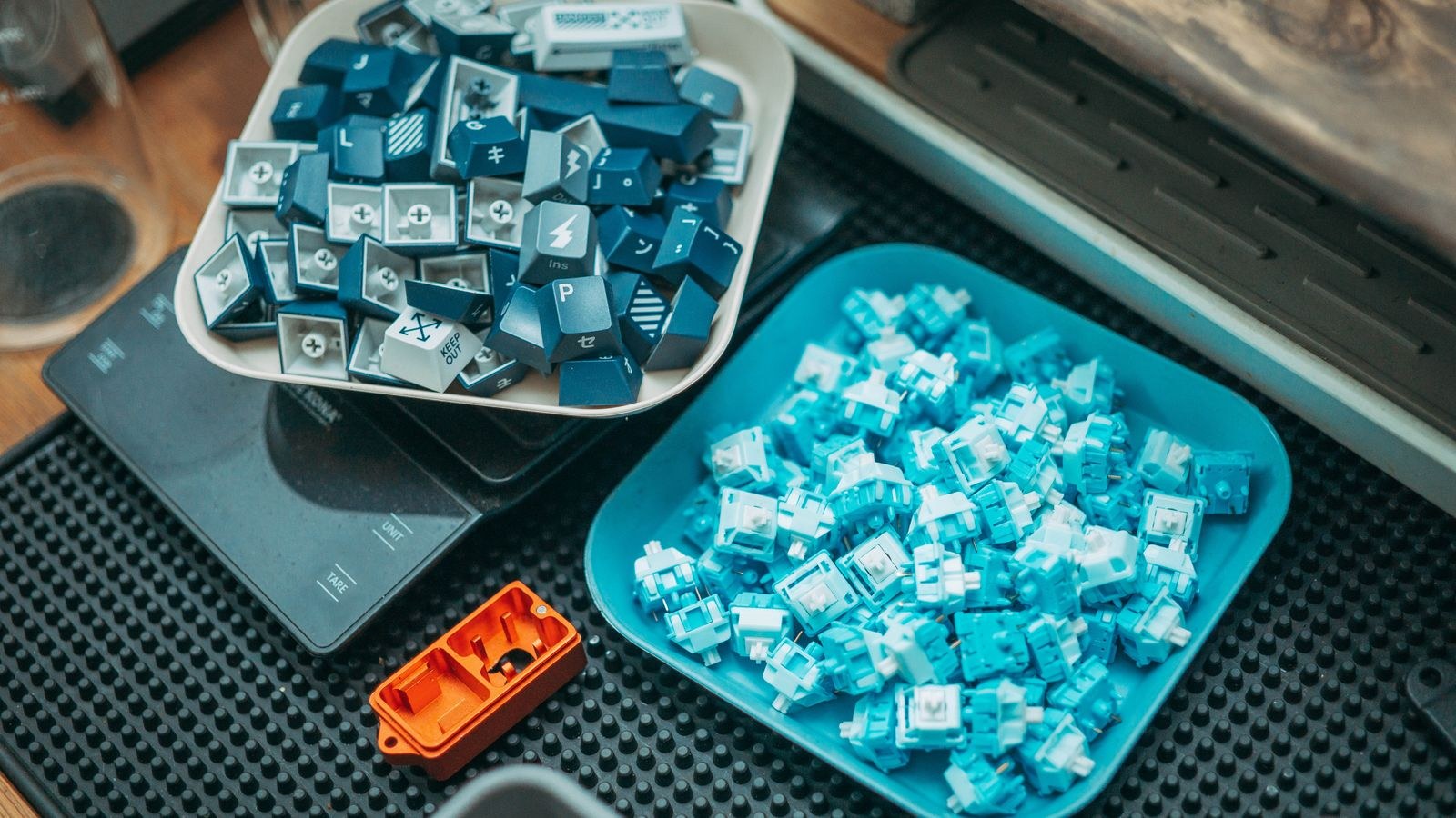 Colorful keyboard keycaps and loose mechanical switches arranged on trays