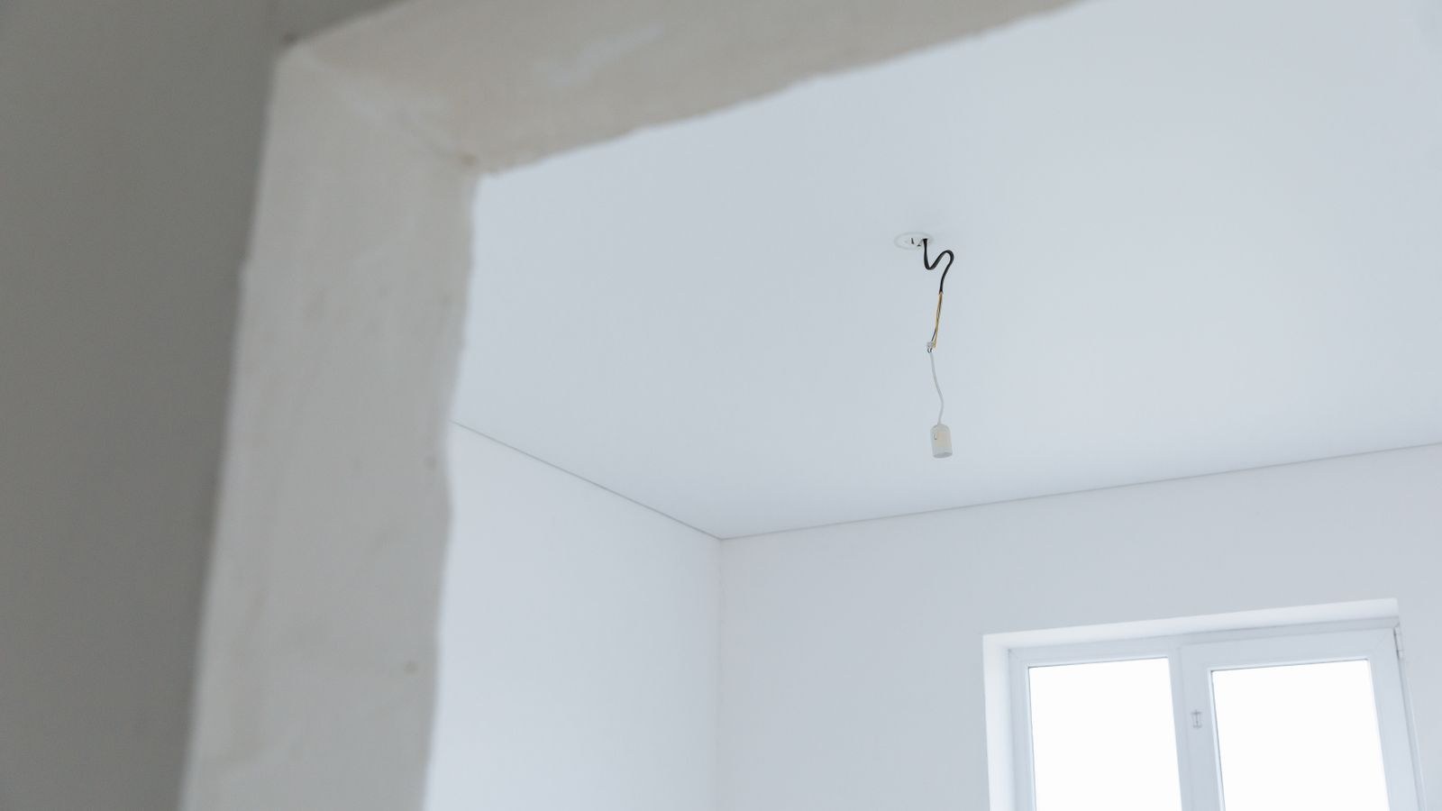 Bright empty room interior showing ceiling and wiring during renovation