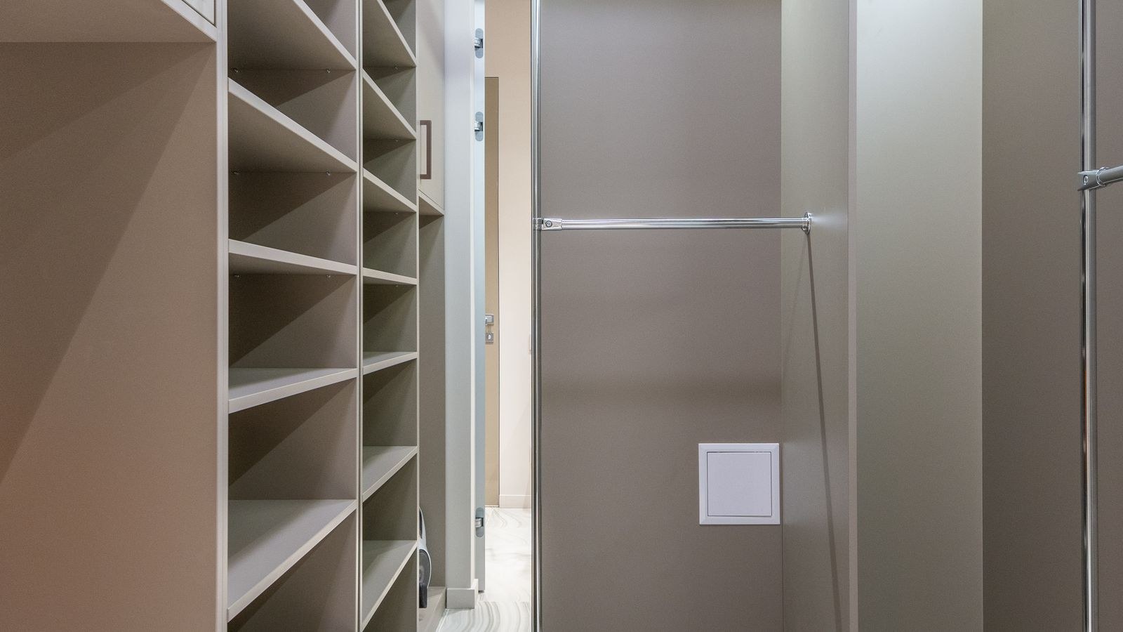 Minimalist walk-in closet with shelves and mirror lit evenly