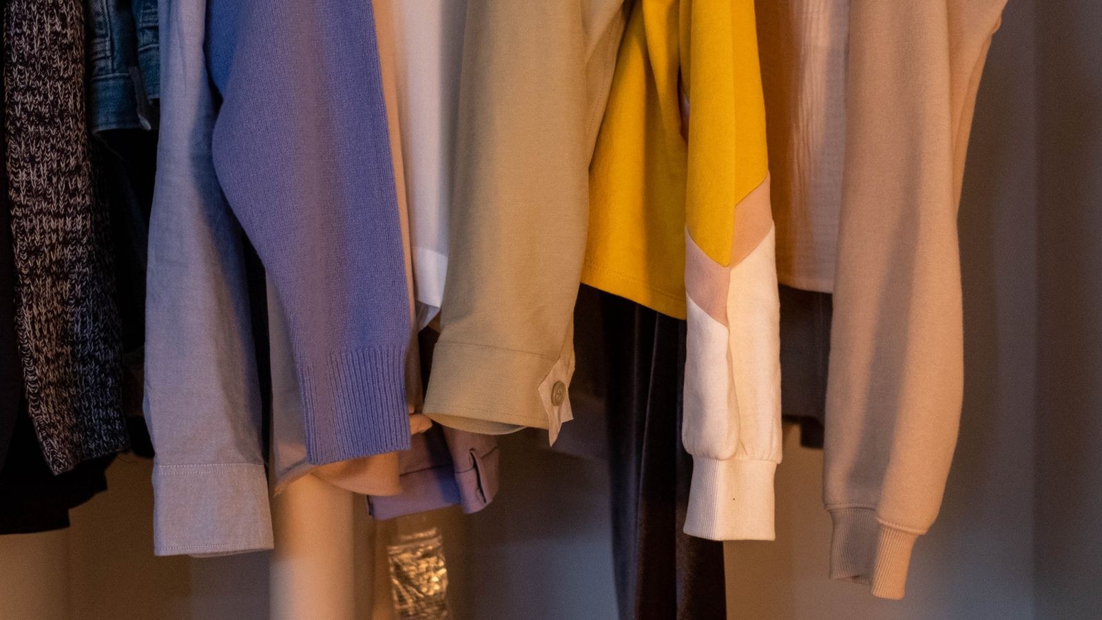 Closet with clothes and shoes neatly arranged on lit shelves